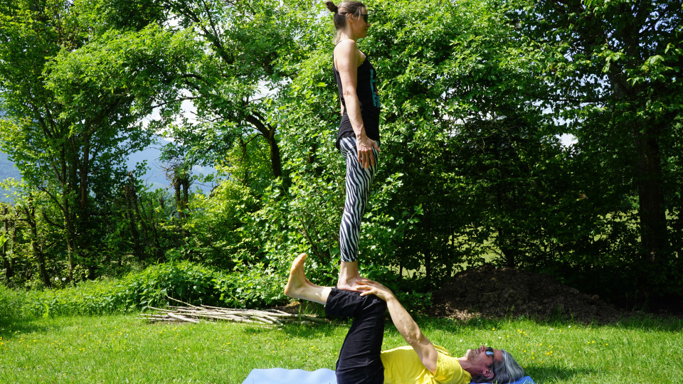 Beim Hinausgehen beugt der Flieger nach vorne und greift die Hände der Base, gemeinsam einatmen und bei ausatmen springt der Flieger seitlich zum Boden. 