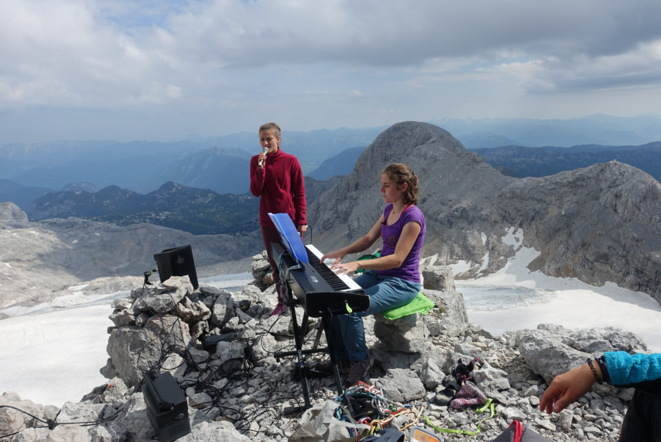 Pianistin und Sängerin musizieren in hochalpiner Bergkulisse